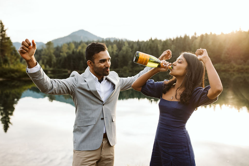 man and woman cheer as they swig champagne