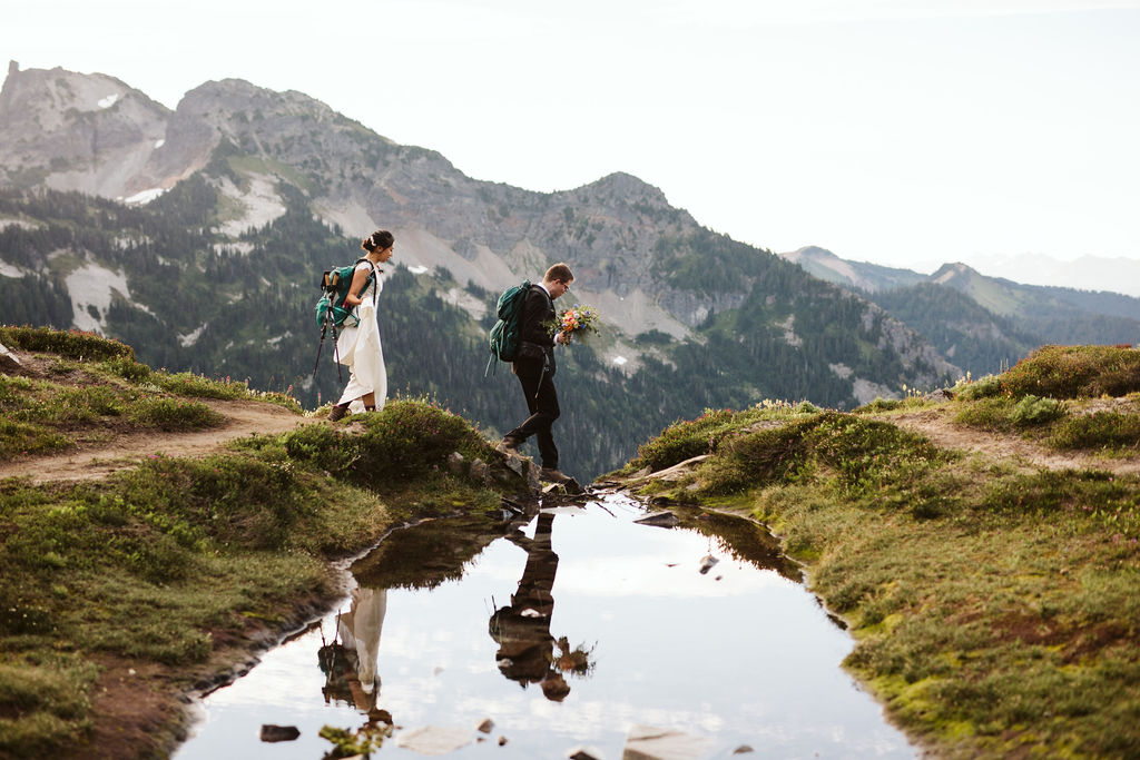 bride and groom walk by lake