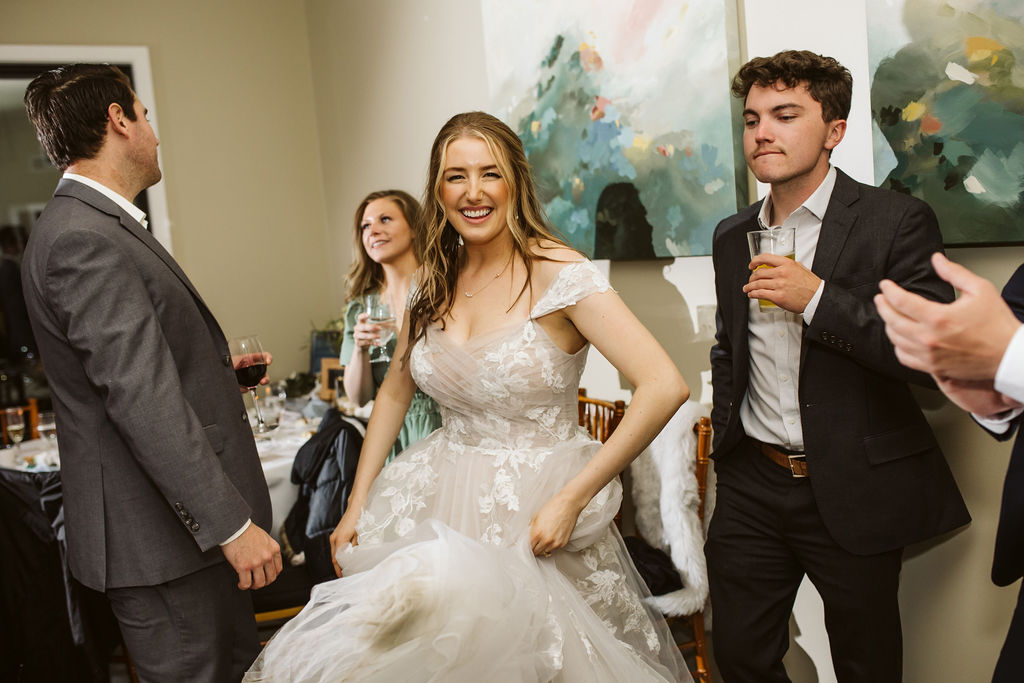 bride smiles as she dances with guests