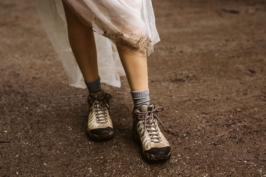 bride shows off hiking boots underneath her wedding dress