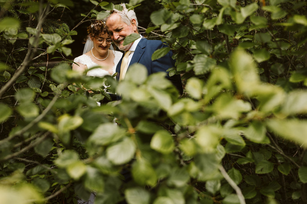 bride and her dad hide amongst the bushes