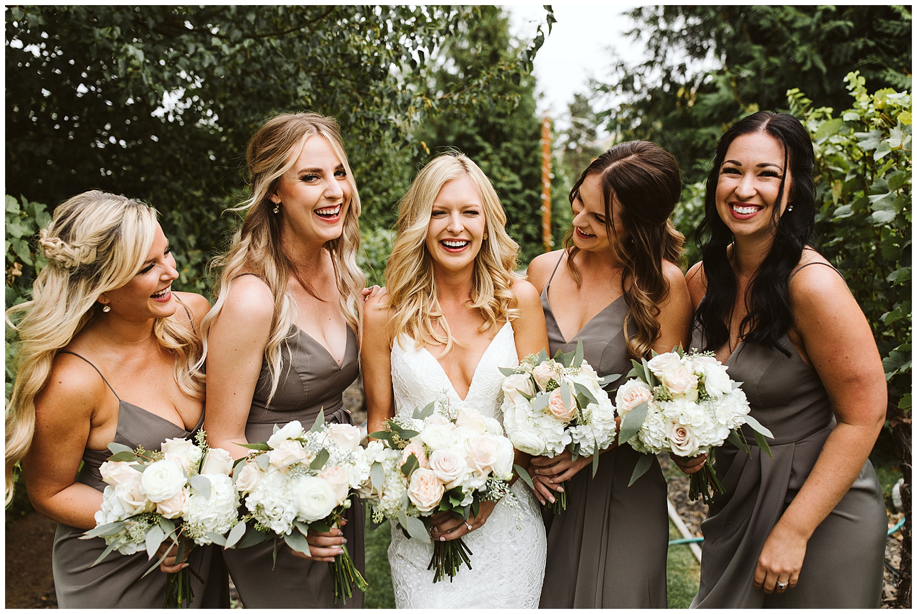 bridesmaids in gray dresses smiling with the bride before the wedding at Karma Vineyards