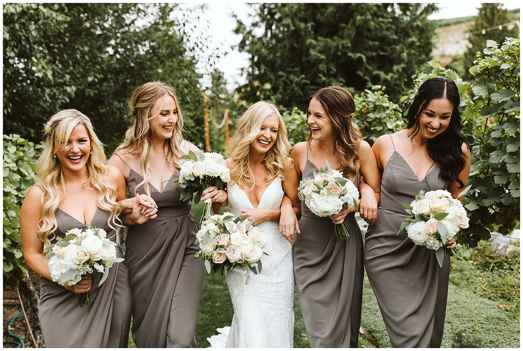 bridesmaids in gray dresses smiling with the bride before the wedding at Karma Vineyards