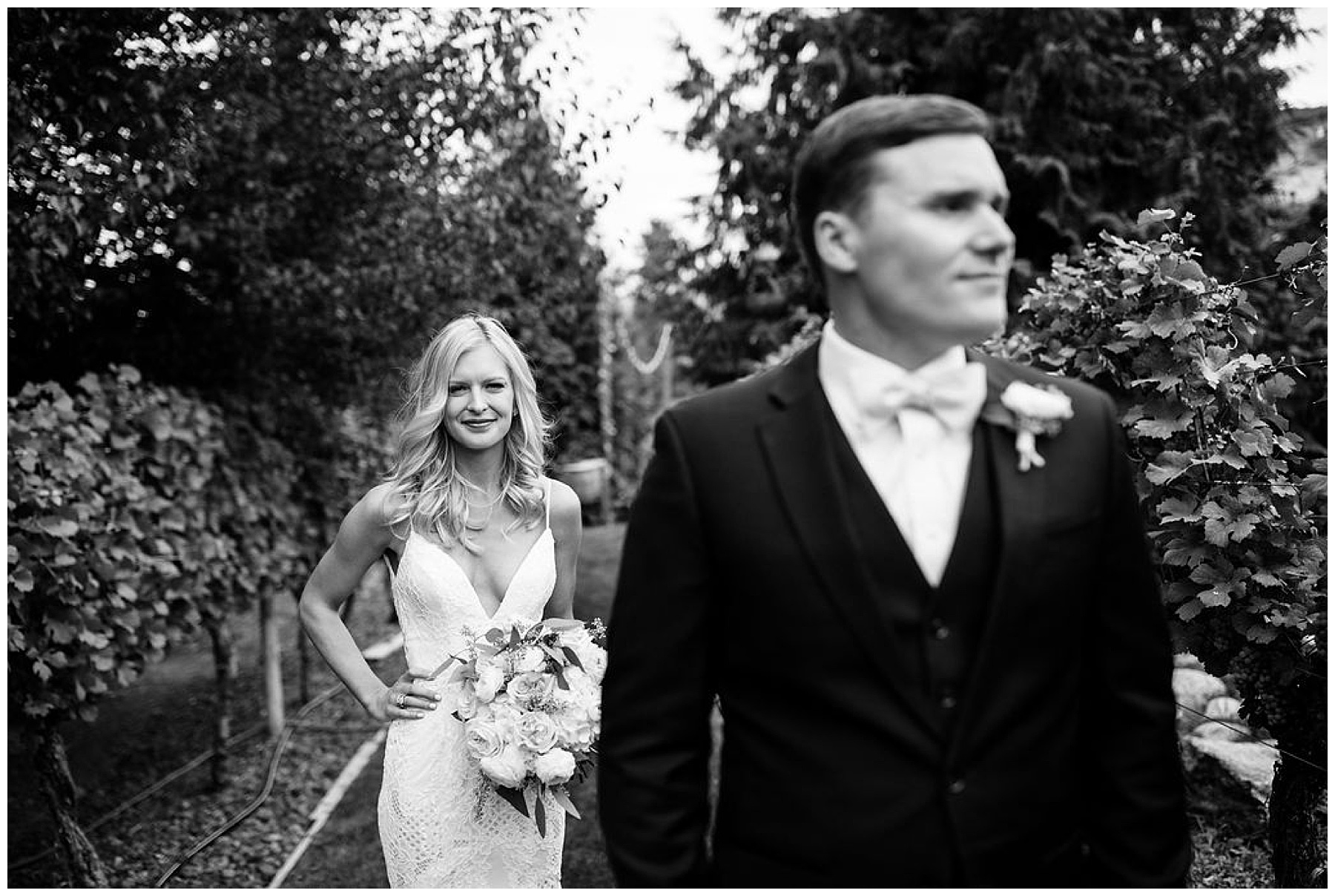 black and white photo of bride standing behind groom.