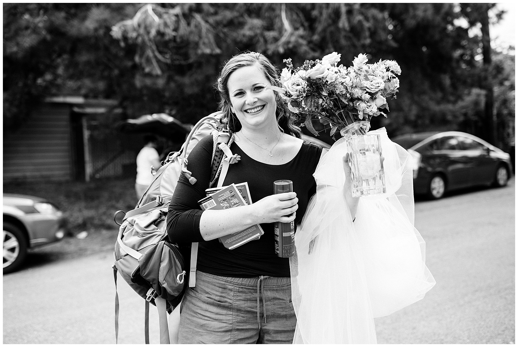 emily holds her veil, dress, and flowers, smiling at the camera before her mount rainier elopement.