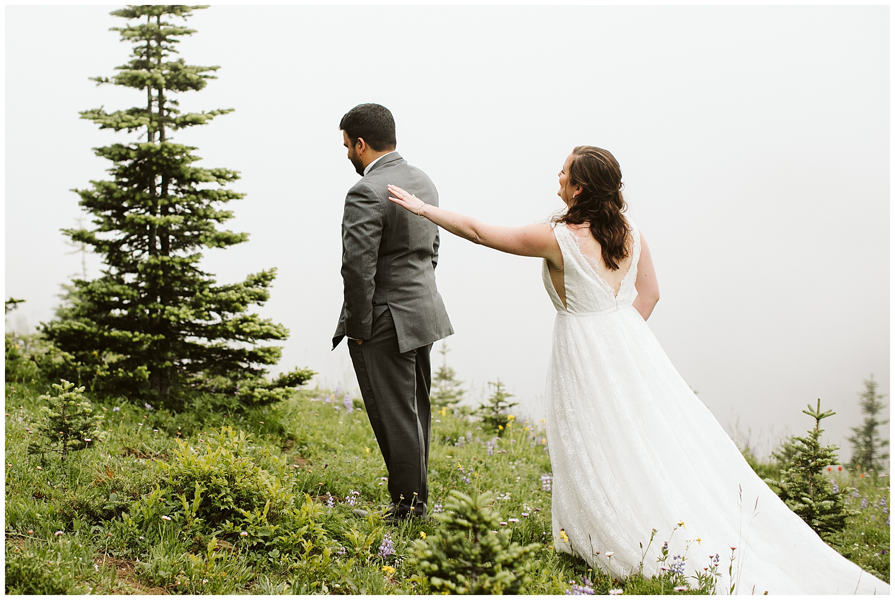 emily touches jay's shoulder for a first look before their elopement ceremony at mount rainier