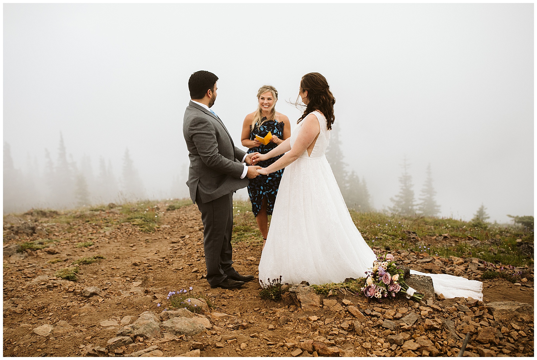 couple holds hands, listening to their officiant at their elopement in mount rainier national park.