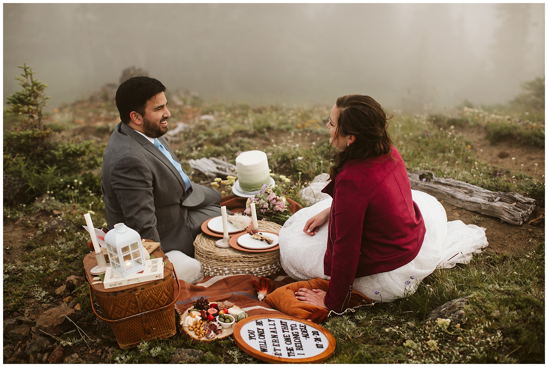 couple sits on a picnic blanket after their elopement ceremony at mount rainier.