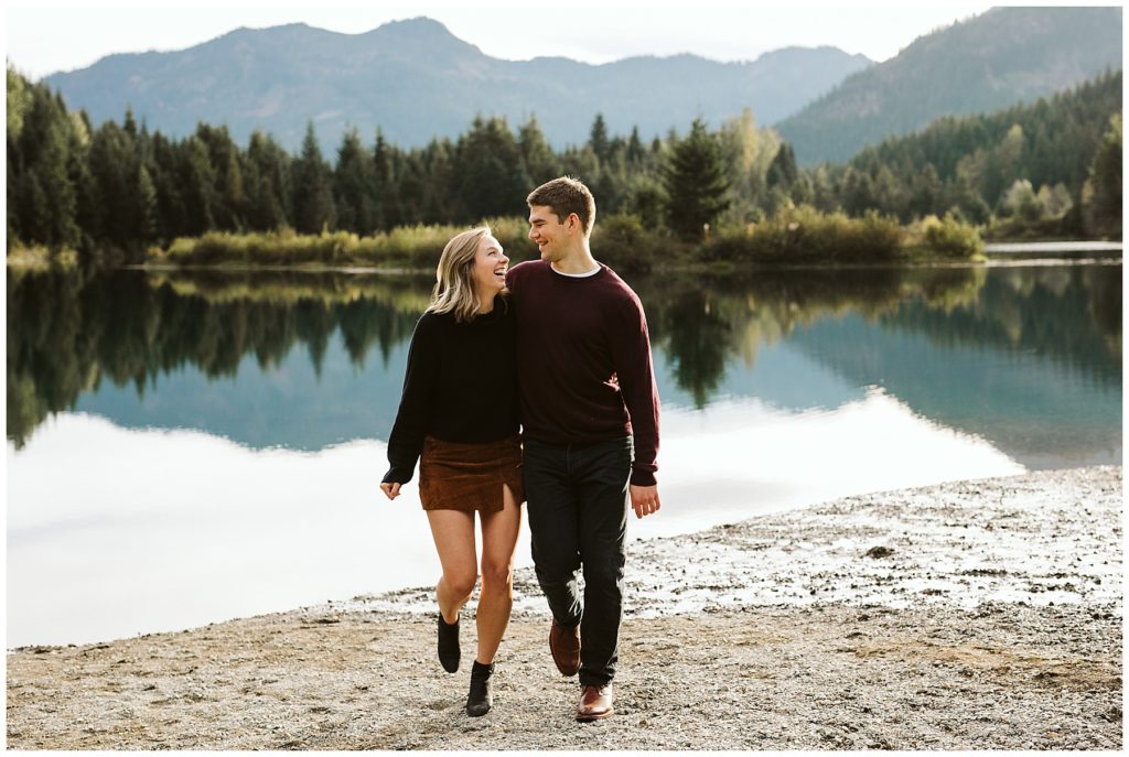 couple walking by lake maroon sweater brown skirt trees