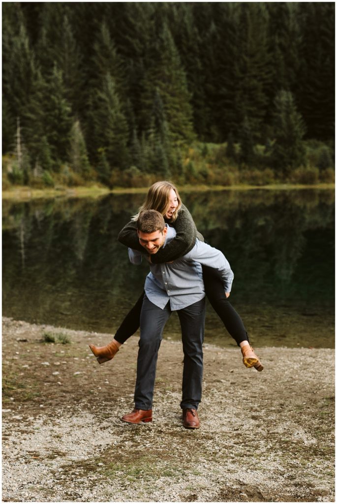 couple having piggyback lake in background