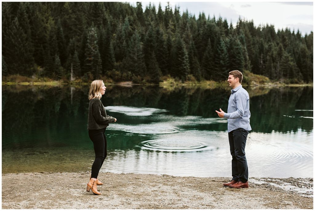 couple skipping rocks in lake