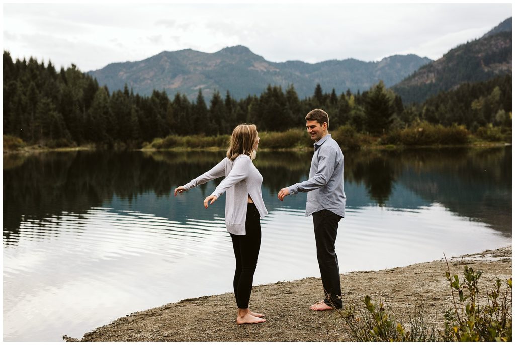 couple standing in front of lake and mountains