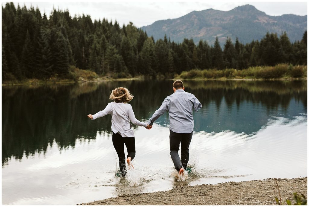 couple running into lake with clothes on 