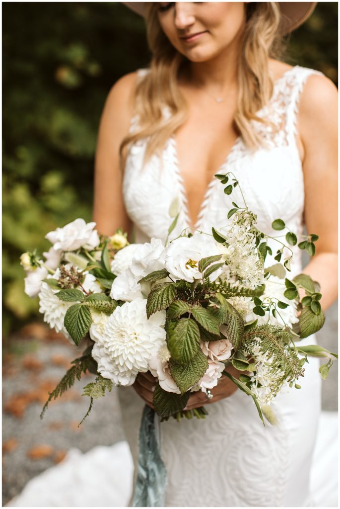 bride with hat on wildflower bouquet 
