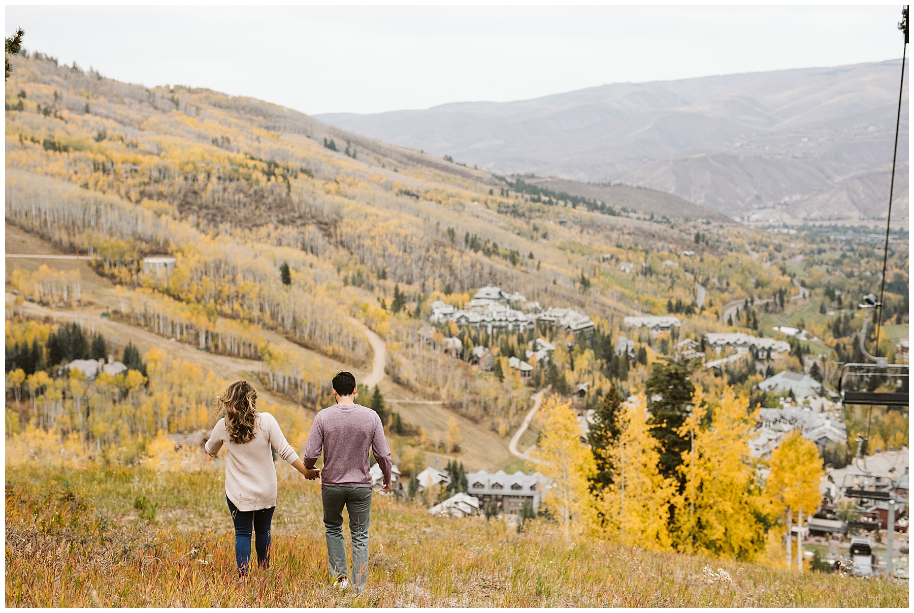 couple walking away toward mountains and aspen trees for their fall engagement photos