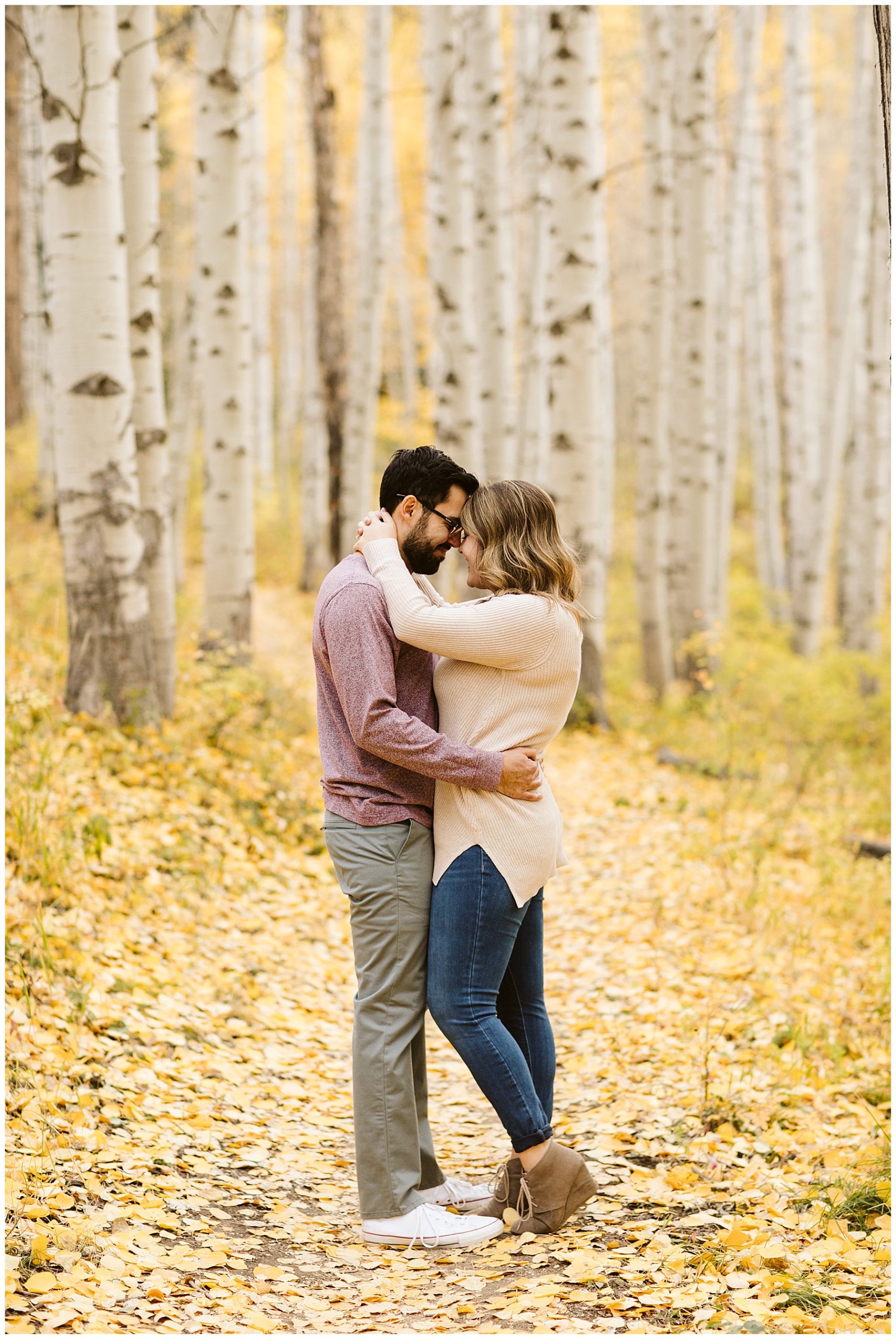 couple kissing in casual outfit in yellow fall aspen tree forest
