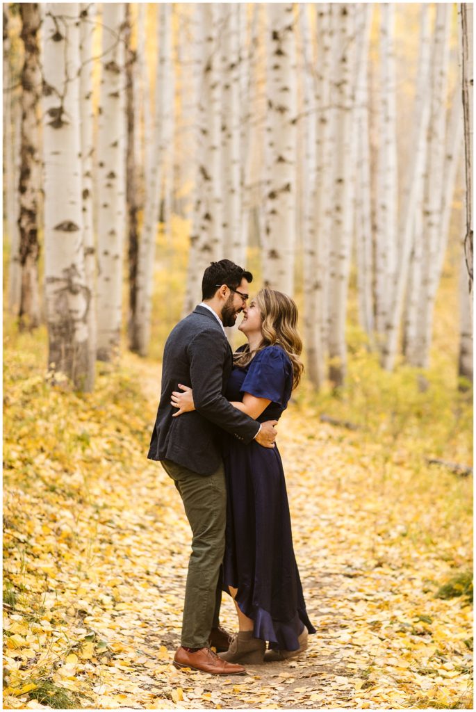 couple touching noses in yellow fall aspen forest