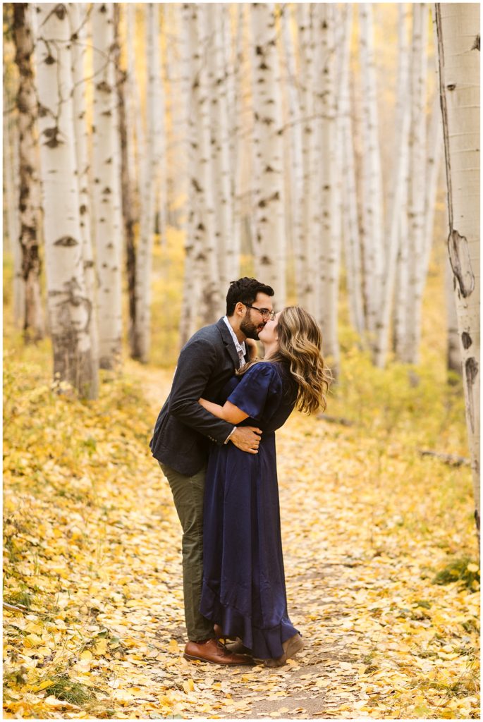 couple kissing in yellow aspen forest