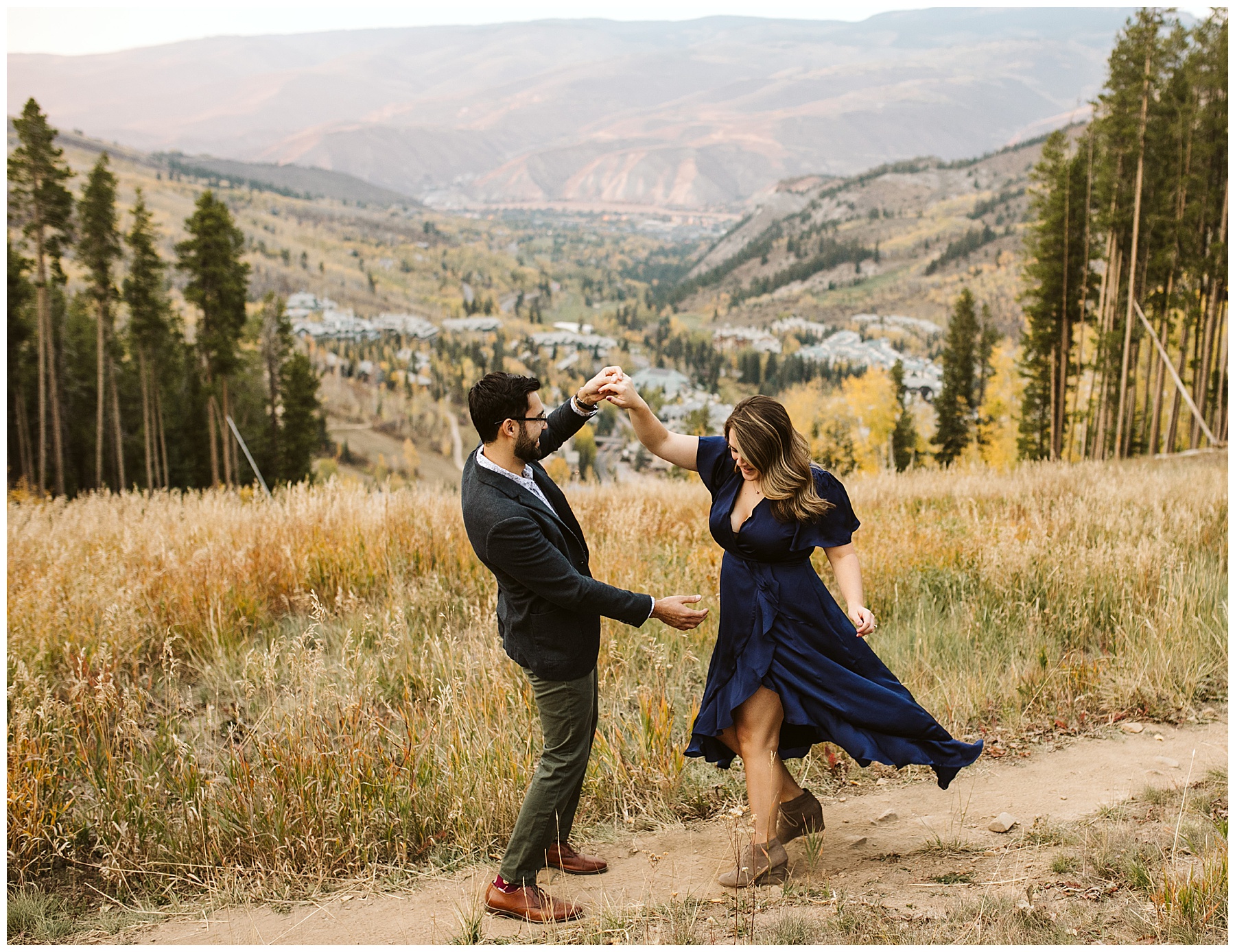 man in gray suit and woman in blue dress fall background; these fall engagement photos were taken in Colorado.