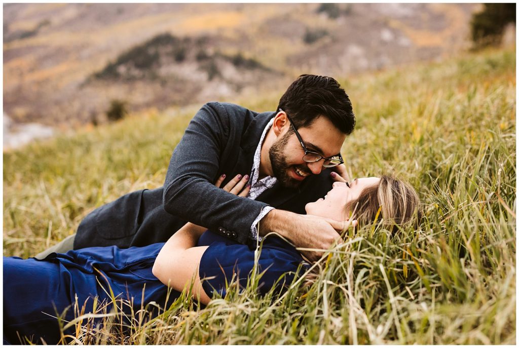 couple kissing in the grass blue dress fall colors
