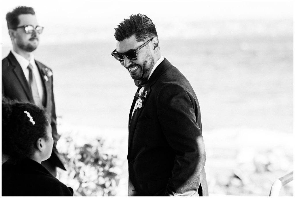 groom smiling with sunglasses on black in white candid photo vashon island elopement