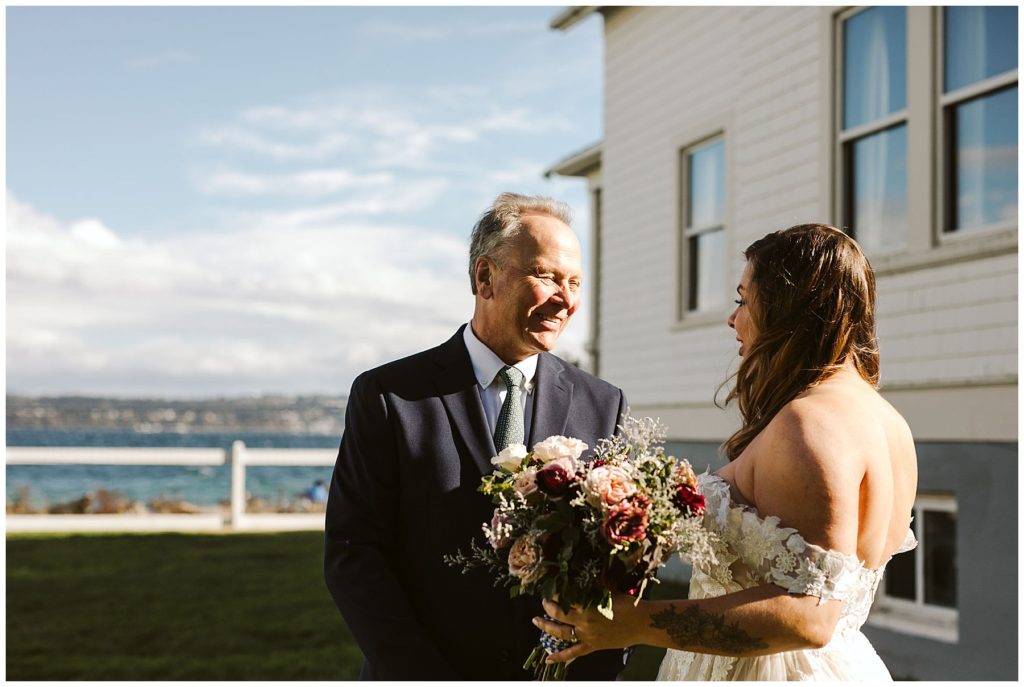 Bride and father of the bride smiling in outside wedding venue by the water vashon island elopement
