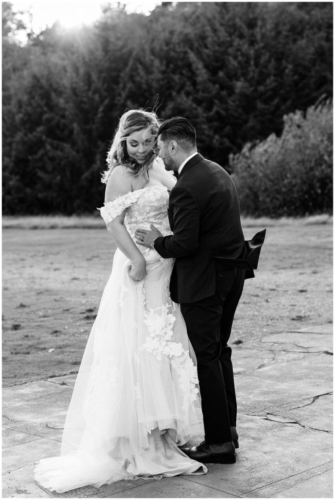 bride and groom dancing and holding each other close black and white photo