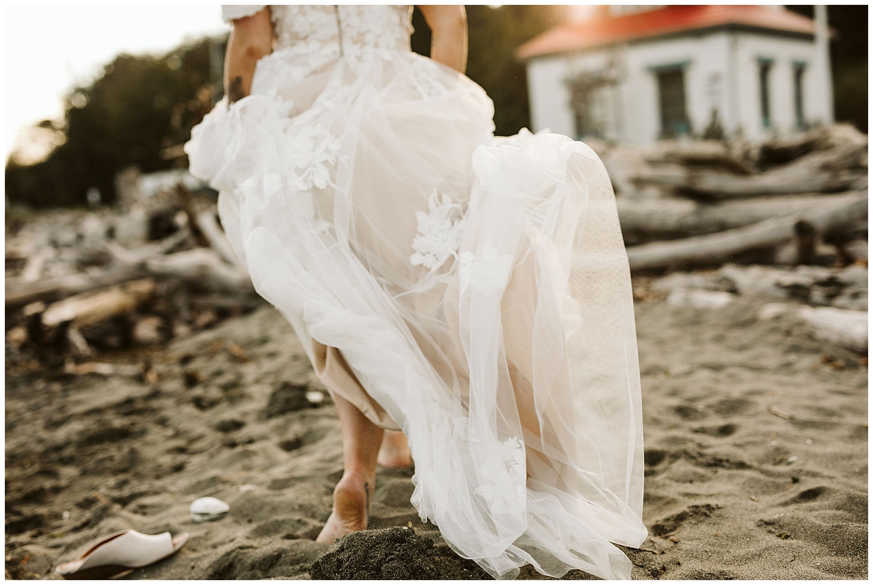 woman walking in sand on the beach in her wedding dress
