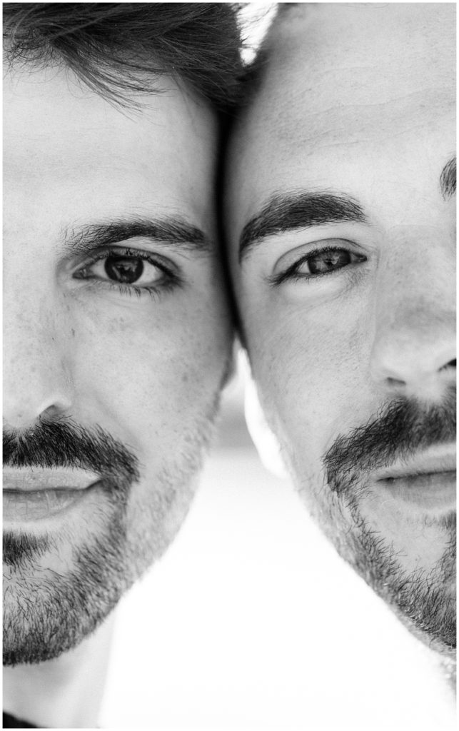 close up photo of two men with heads together side by side zoomed in to show both faces