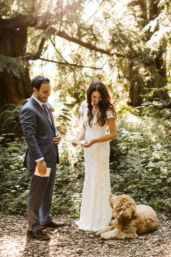 wedding couple sharing vows in the forest while laughing