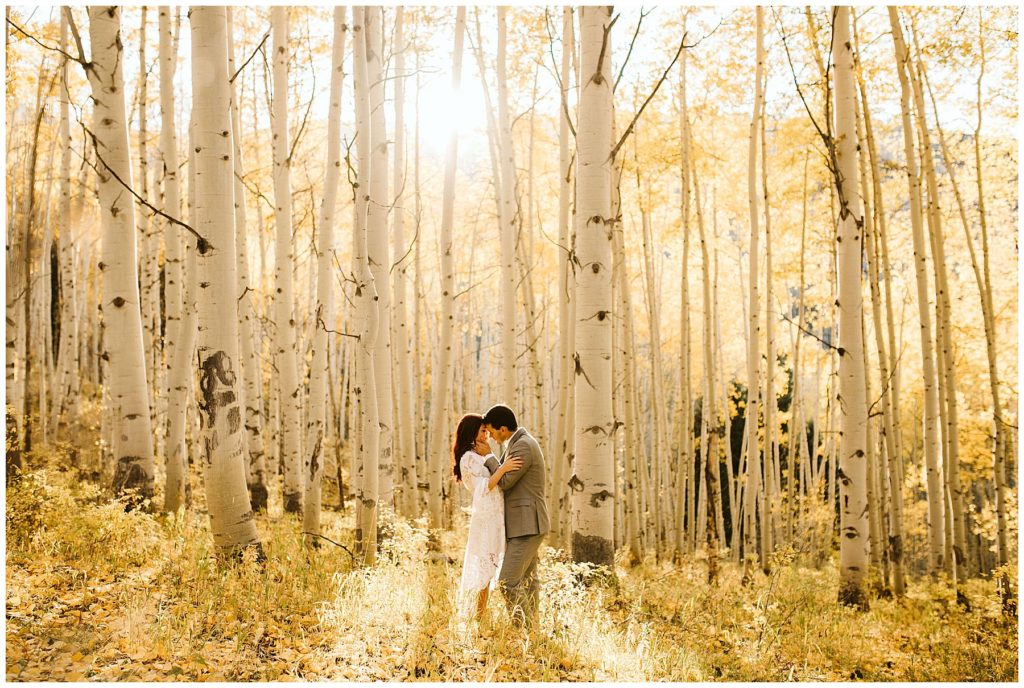 couple kissing with the aspen wood in the background