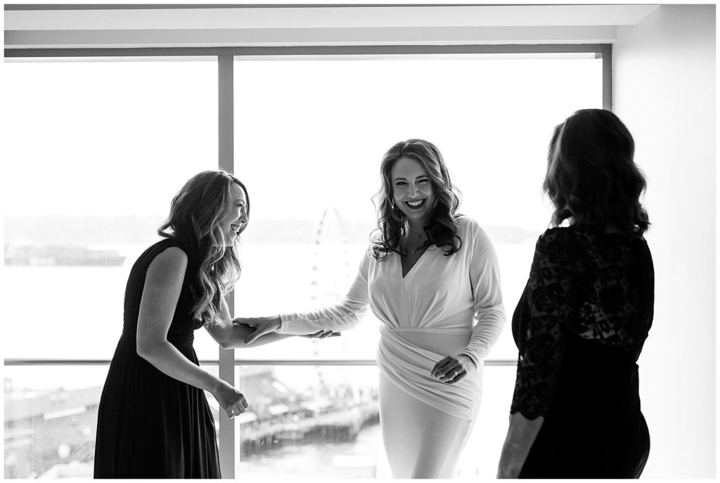 black and white photo of glamorous bride laughing with her mom and sister
