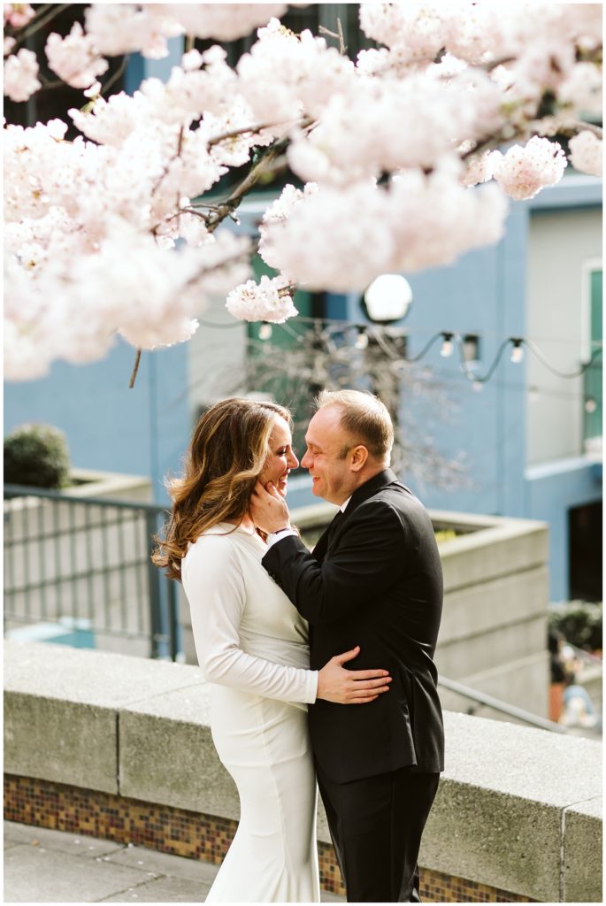 bride and groom with cherry blossoms framing the picture