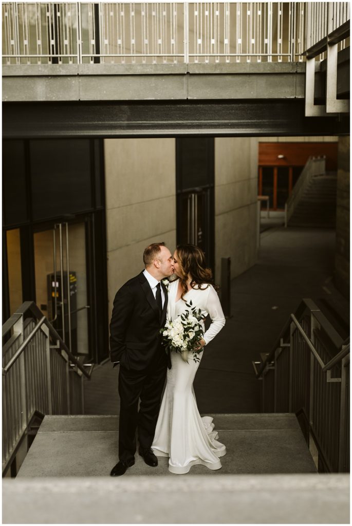 bride and groom kissing in stairwell