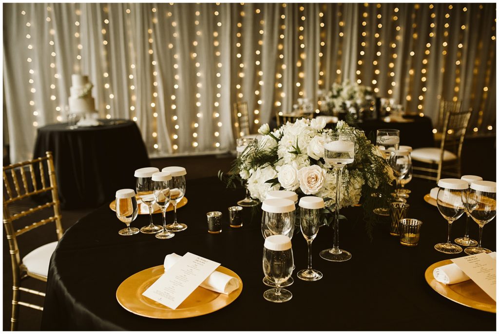 wedding reception with white flowers and gold plates 