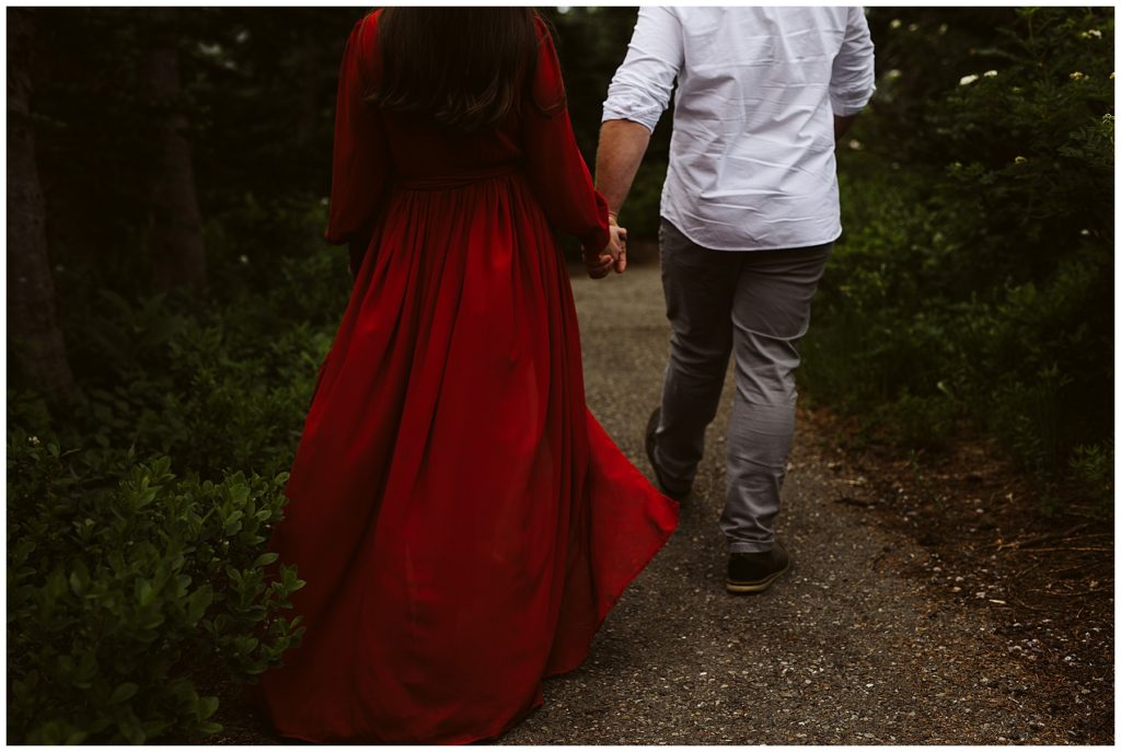 image of couple walking with red dress flowing at mount rainier shot by kelly lemon photography