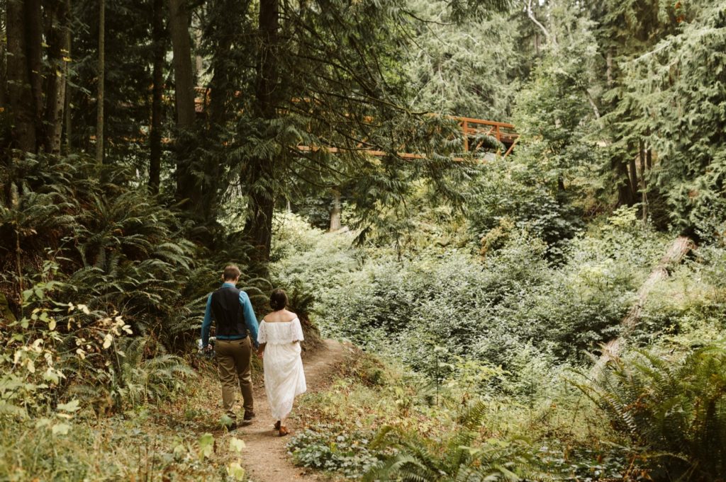 couple-walking-through-lush-forest-at-Olympic-peninsula-in-Washington-state