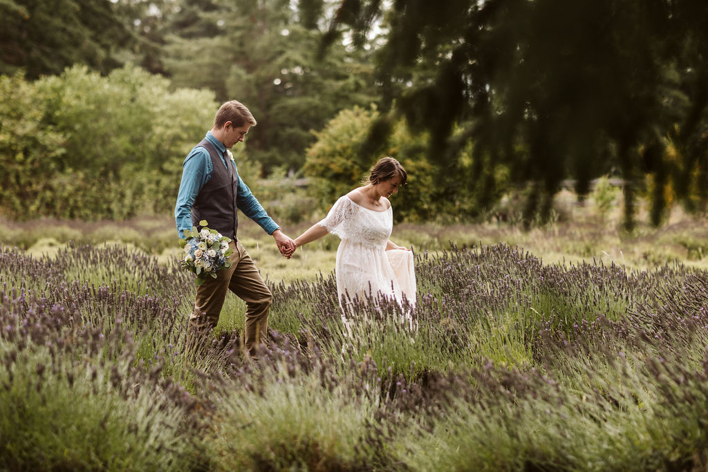 bride and groom walk through lavender during wedding portraits