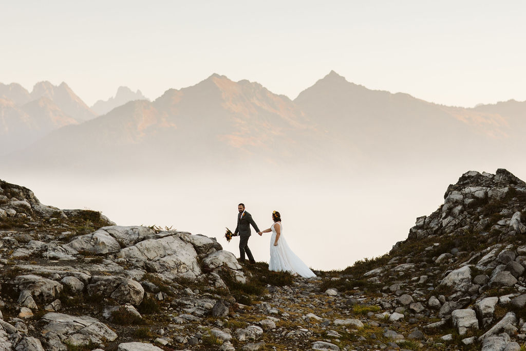 bride and groom walk on edge of cliff during north cascades elopement
