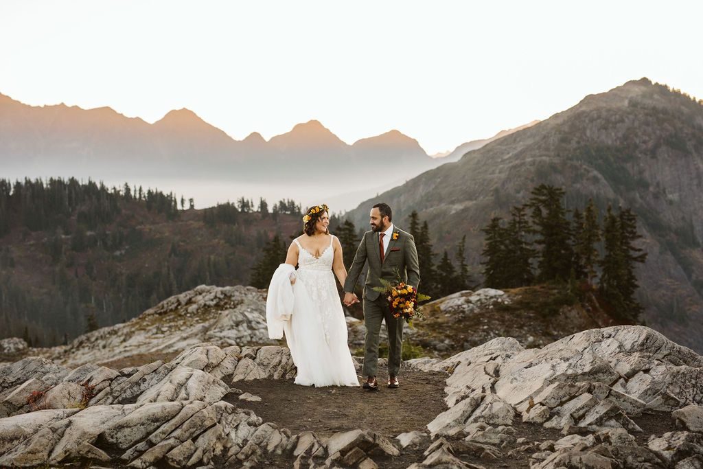 bride and groom walk on dirt path with mt baker wilderness around them