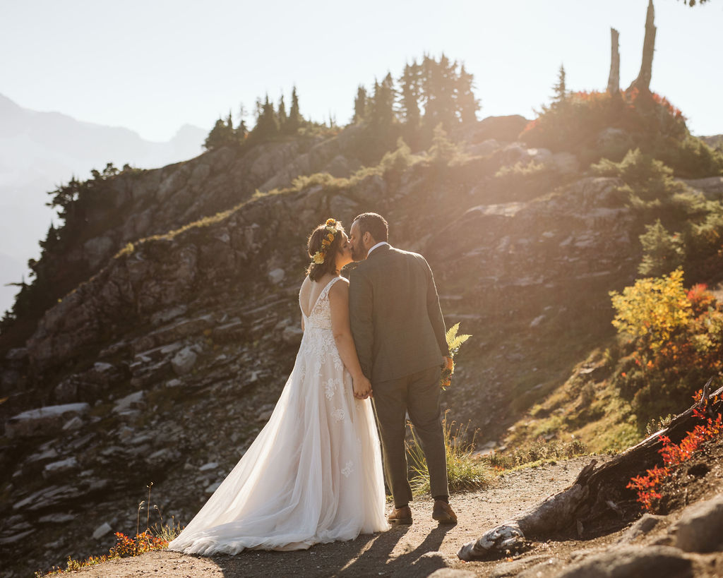 bride and groom kiss in sunlight during artist point elopement
