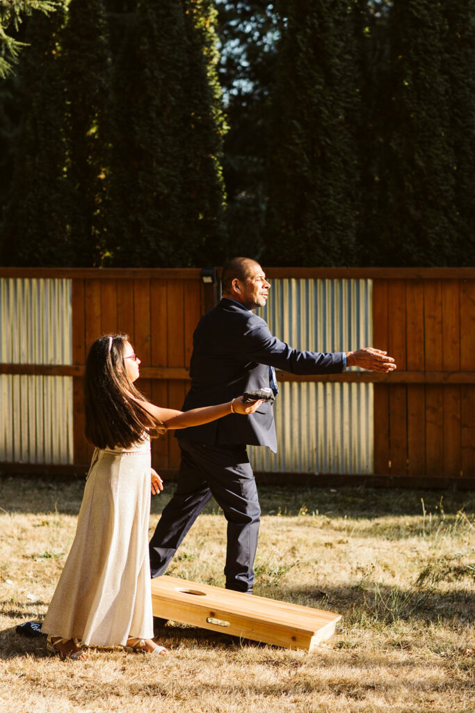 man and smaller girl play lawn game at airbnb wedding