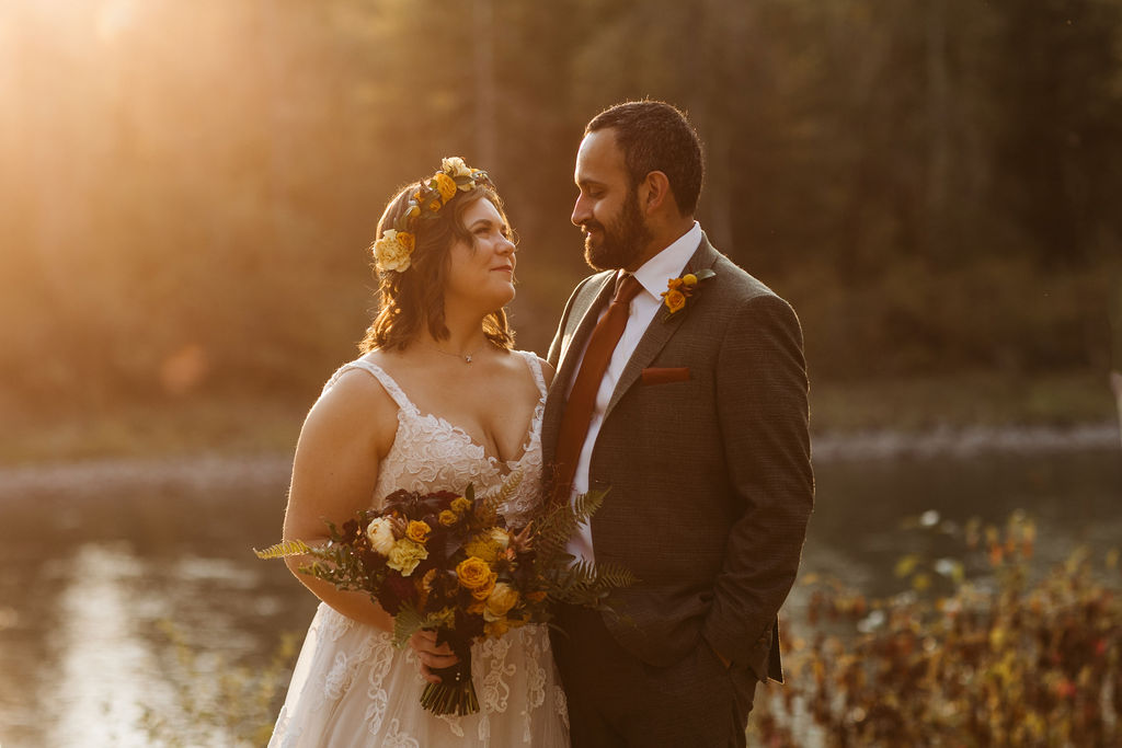 bride and groom smile at each other during sunset photos
