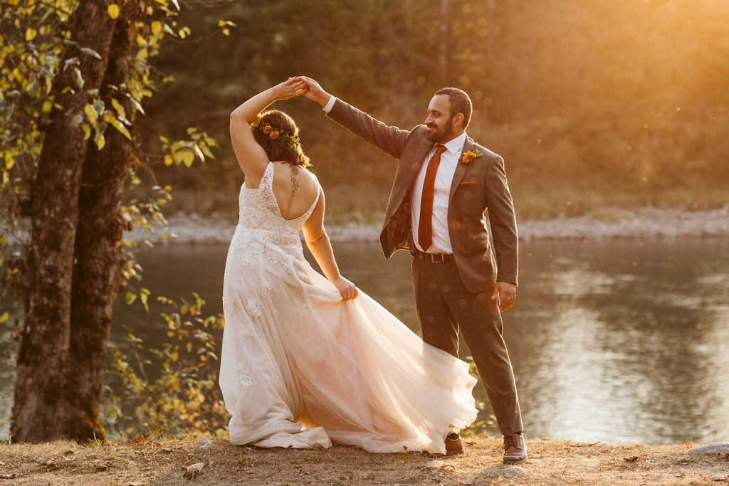 groom spins bride around during sunset
