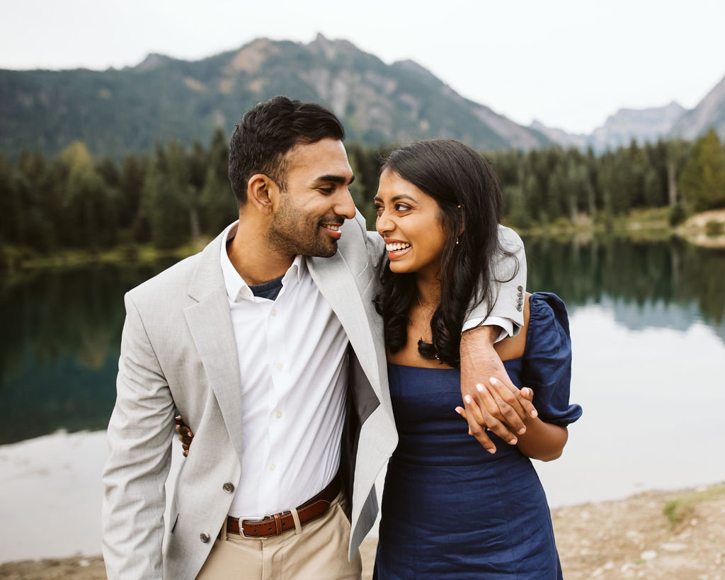 boy and girl walk in front of lake at Gold Creek Pond engagement session
