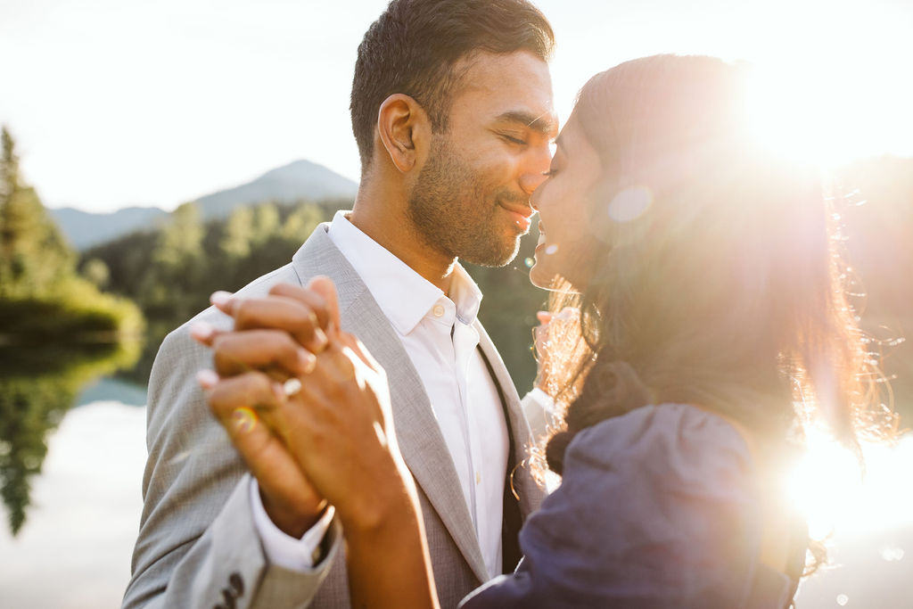 man and woman hold hands and lean into each other during gold creek engagement shoot