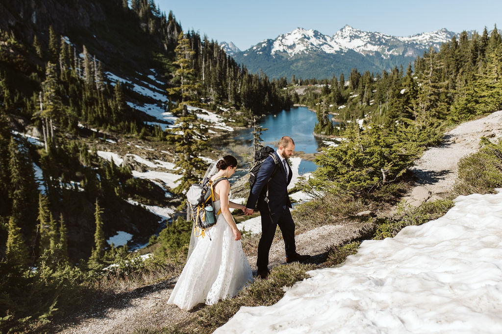 bride and groom hike a mountain for elopement