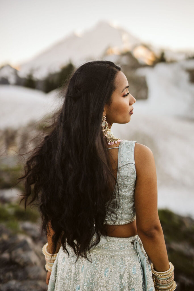girl stares over should with long dark hair blowing in wind