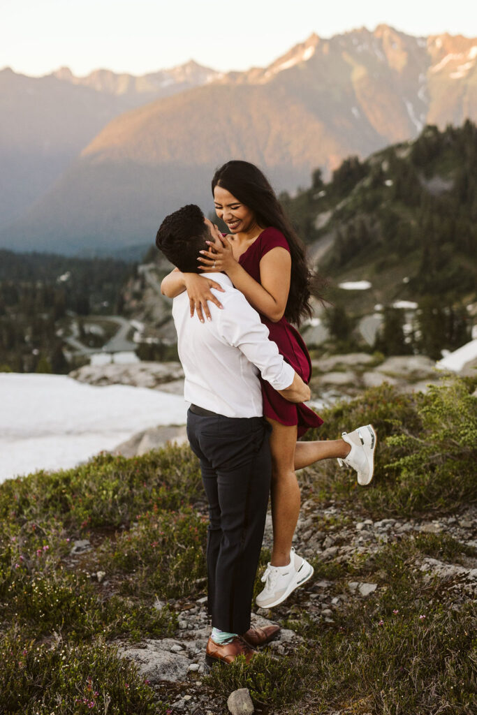 boy picks up girl and she kicks her legs out during mt baker engagement session