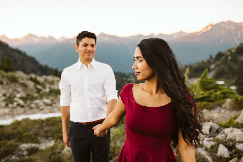 girl leads boy with mountains in the background during engagement shoot
